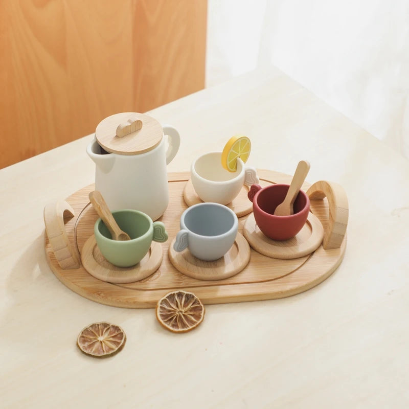 Set of ceramic cups and teapot with wooden elements on a light surface