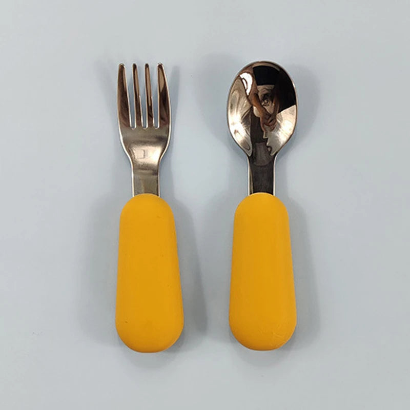 Fork and spoon set with yellow handles on a light gray background