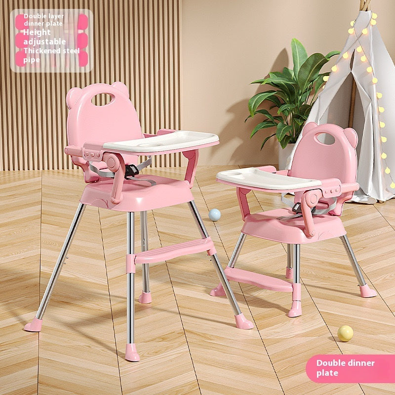 Pink adjustable high chair with tray on a wooden floor.