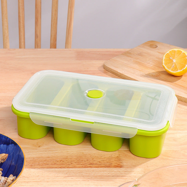 Green and clear plastic container on a wooden table with a lemon in the background