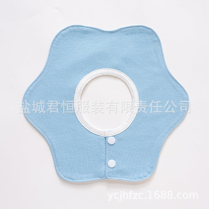 Light blue fabric bib with white buttons on a light gray background