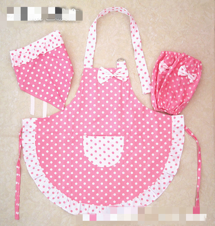 Pink apron with white polka dots and matching headband on a beige background