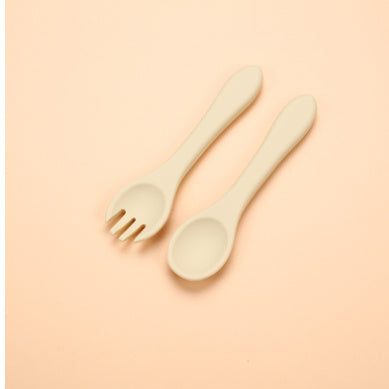 Wooden fork and spoon set on a beige background