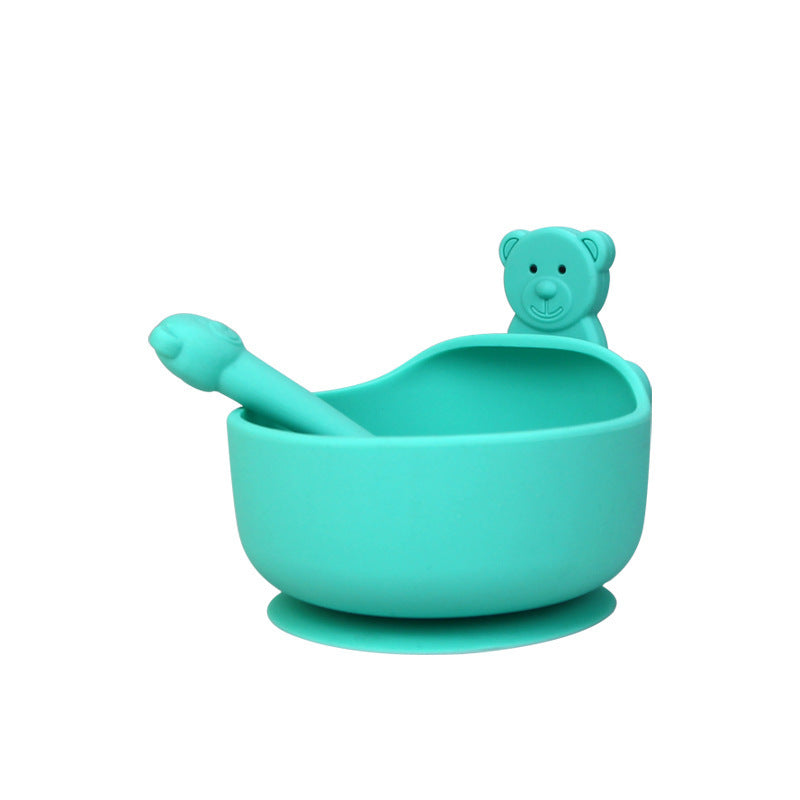 Turquoise silicone bowl with spoon and bear-shaped handle on a white background