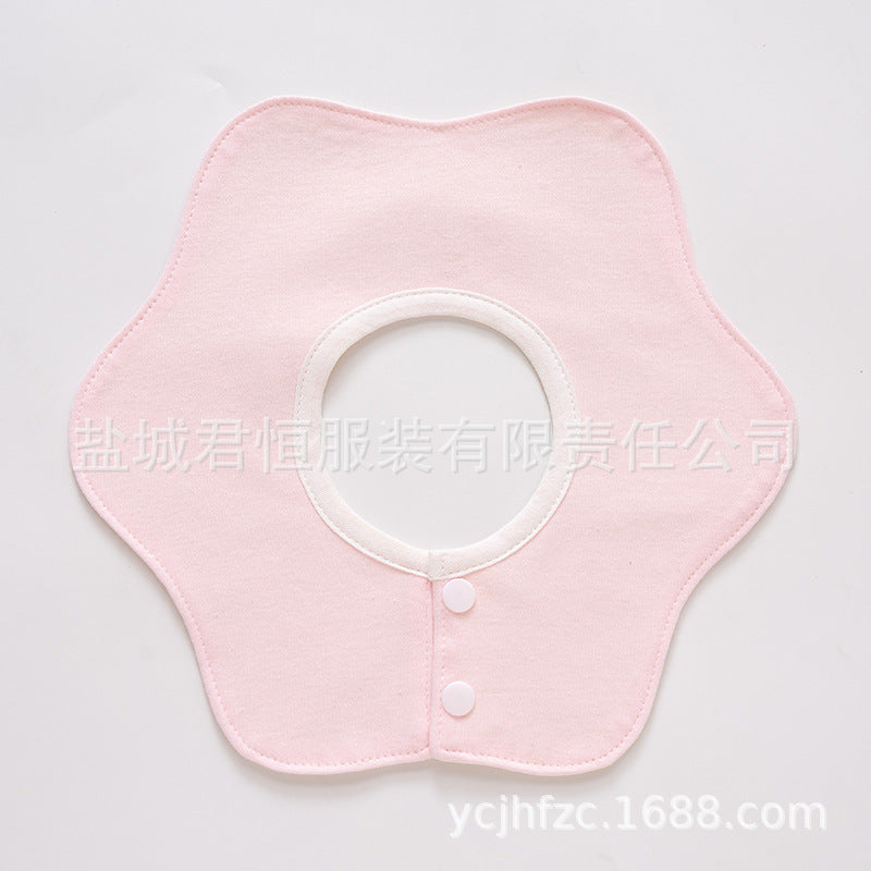 Pink baby bib with white buttons on a light gray background
