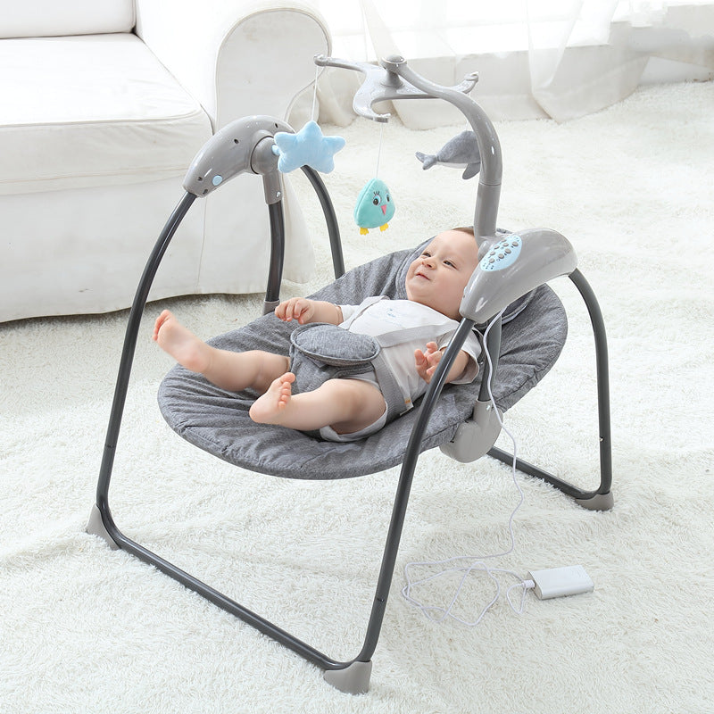 Baby in a gray baby swing with toys on a white carpet