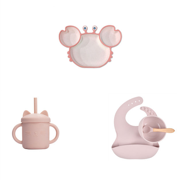 Set of pink baby products including a sippy cup, bib, and teether on a white background