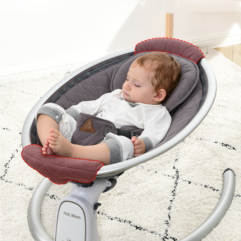 Baby in a gray and red baby swing on a light-colored floor.