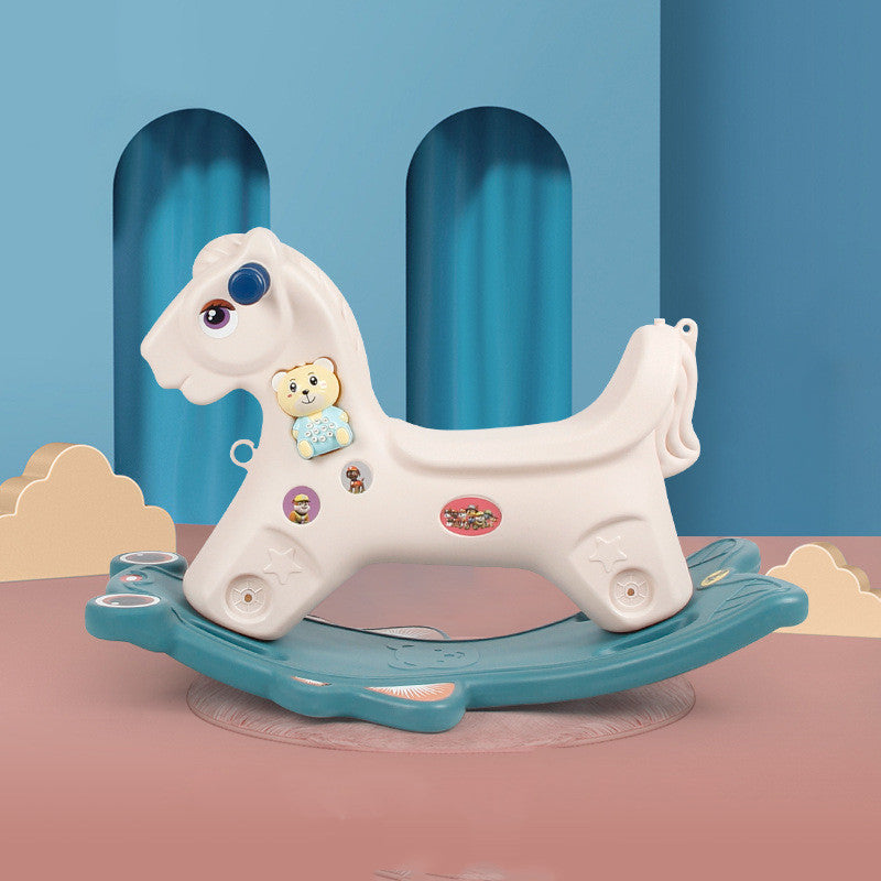 White rocking horse with blue base on a pink platform against a blue curtain background
