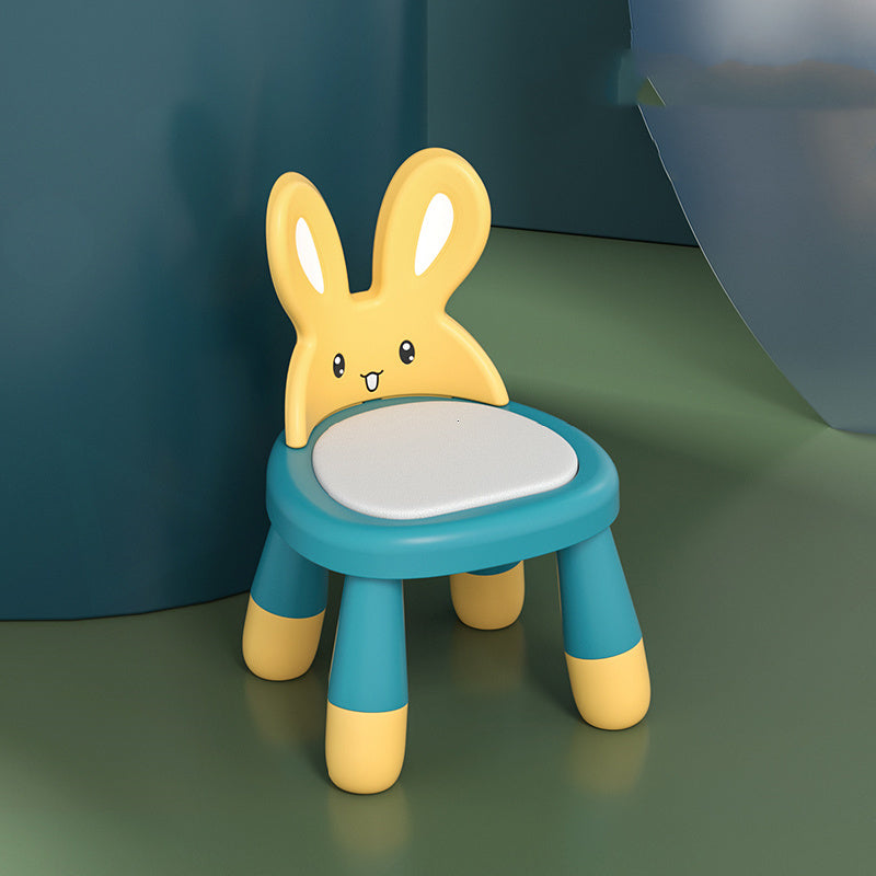 Children's chair designed like a yellow rabbit on a green surface with a blue background