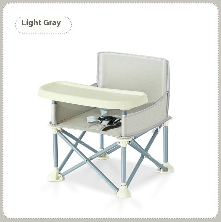 Light gray folding chair with a tray on a white background