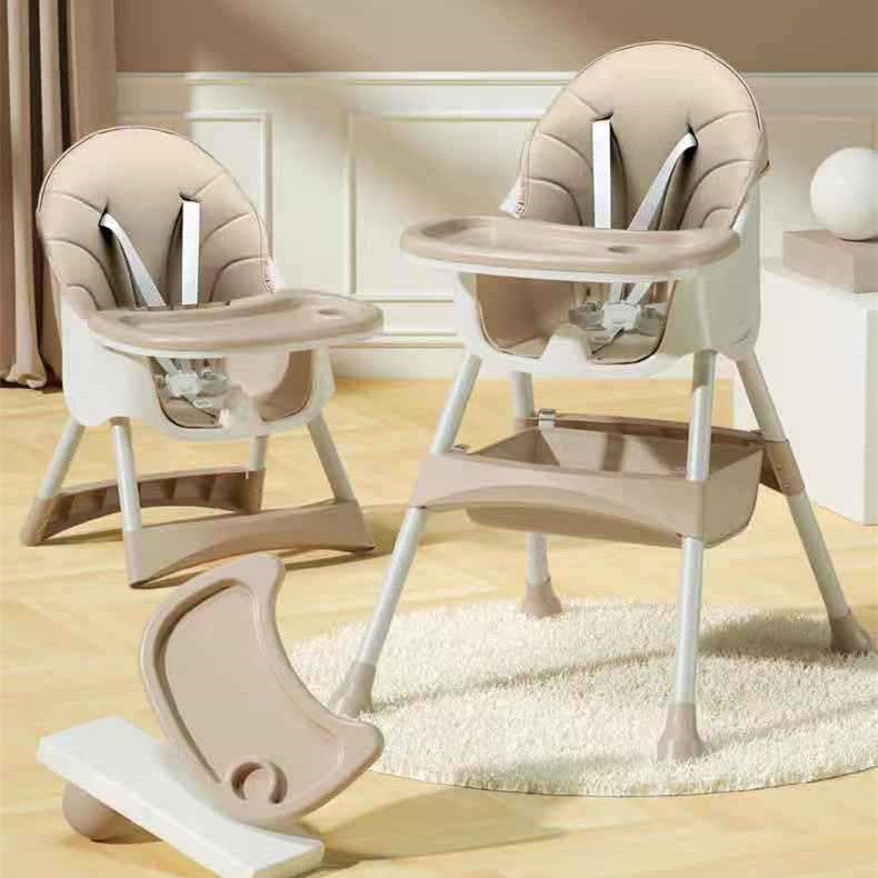 Beige and white baby high chair with additional tray on a light wooden floor.