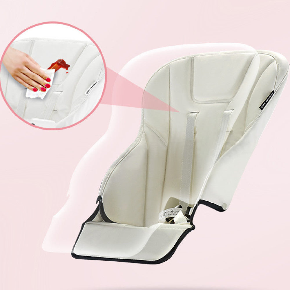 White baby seat with a close-up of a hand cleaning it on a pink background