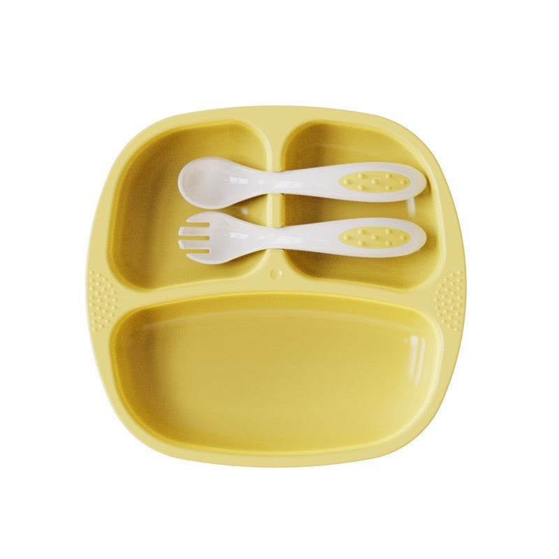 Yellow children's plate with divided sections and white utensils on a white background