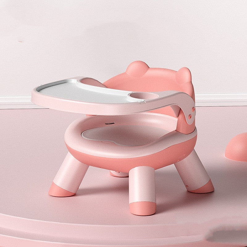 Pink and white children's chair with a small table on a light pink background