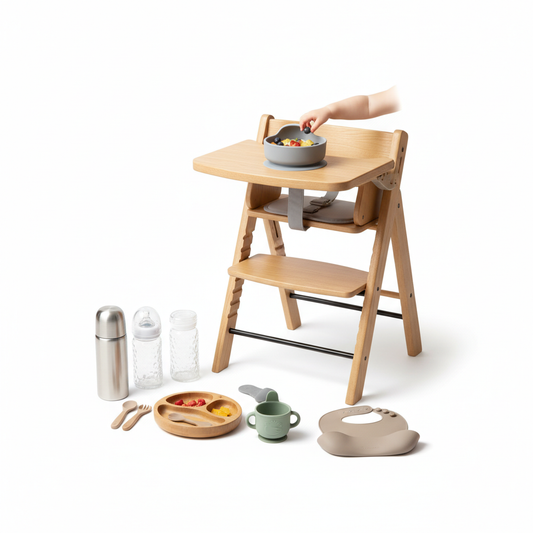 a light wood high chair with a toddler's hand reaching for food in a gray suction bowl on the tray.