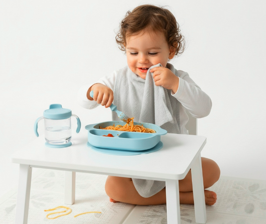 Baby independently eating spaghetti, wiping face with cotton towel