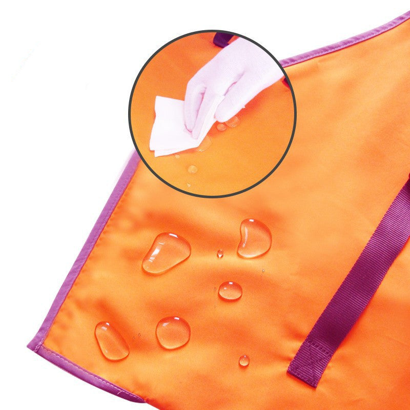 Orange towel with purple trim showing water droplets and a hand wiping it, on a white background.