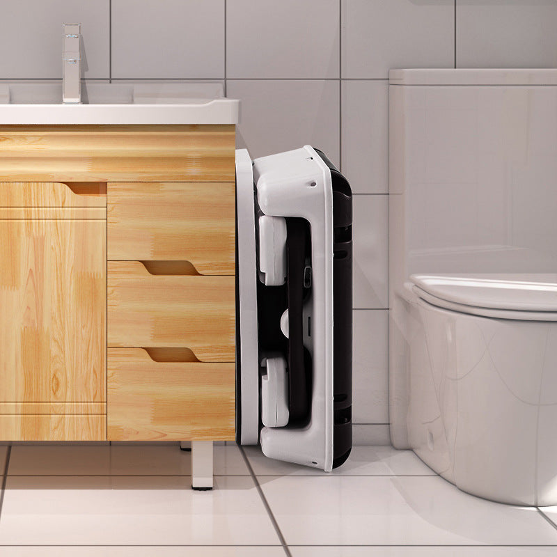 Hand dryer mounted on a tiled bathroom wall next to a wooden vanity and toilet.