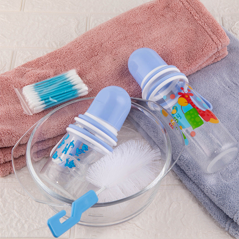 Bottle cleaning brush set with baby bottle and cleaning solution on a towel