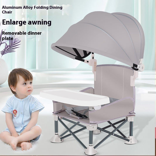 Child sitting next to a gray aluminum alloy folding dining chair with an enlarged awning and removable dinner plate.