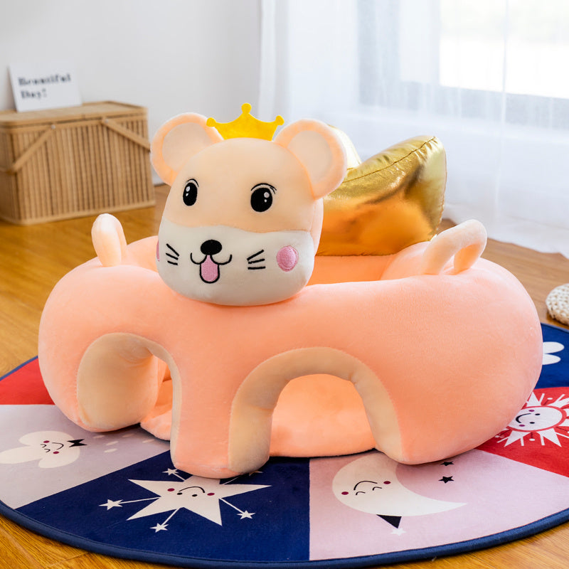 Plush toy shaped like a cartoon mouse with a crown on a colorful rug.