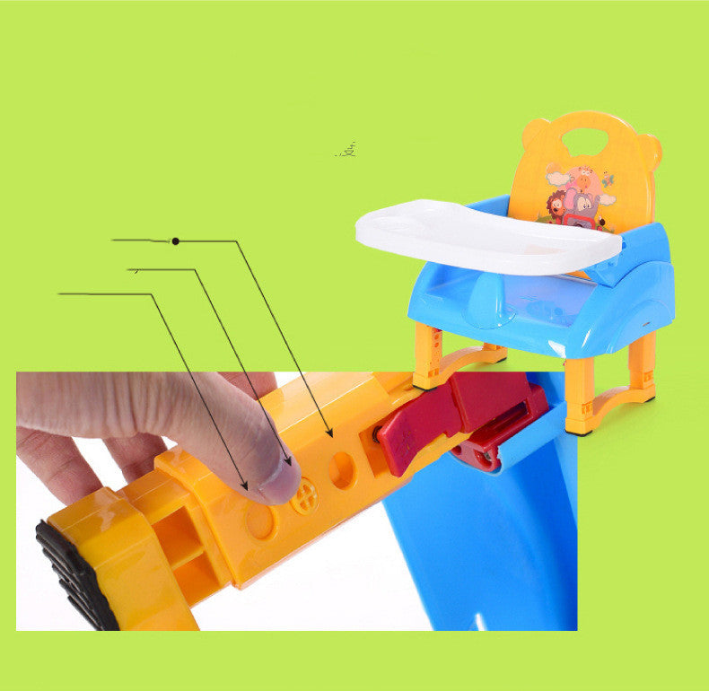 Children's toy train set with a blue and orange track and a small chair with a cartoon character on a green background.