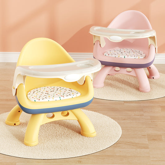 Yellow and pink baby training seats on a wooden floor with a beige wall background.