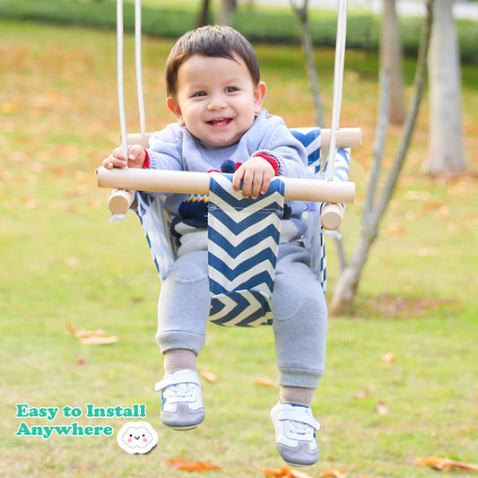 Child on a swing set with a grassy background