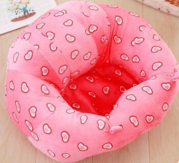 Pink pet bed with heart patterns on a wooden floor
