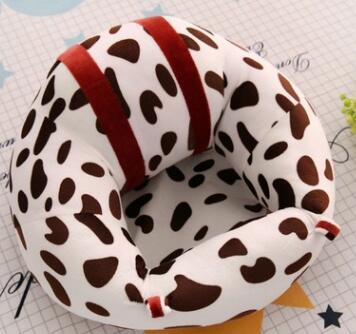 U-shaped pillow with cow print pattern on a textured surface