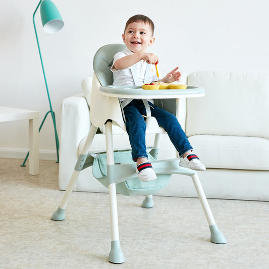 Child sitting in a high chair with a tray, eating indoors.