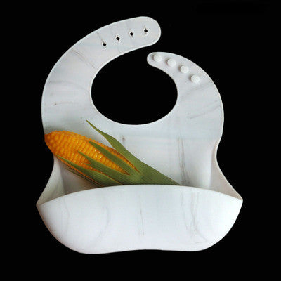 White silicone bib with corn and green leaves on a black background