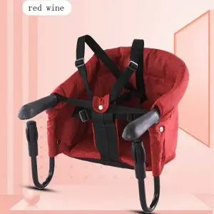 Red baby seat with black straps on a pink background