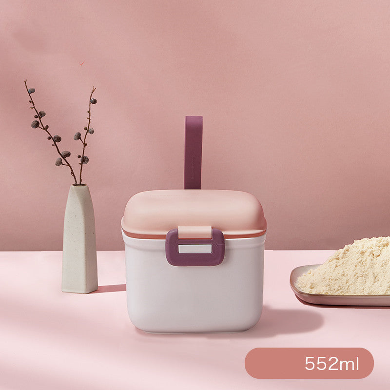 Pink and white container with a straw on a pink background, featuring a vase and dish of food.