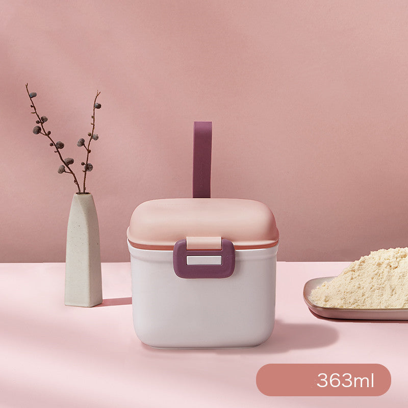 Pink and white container with a straw on a pink background, featuring a vase and bowl of rice.