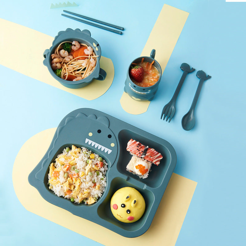 Children's lunch set with dinosaur-shaped tray, bowls, and cutlery on a blue background