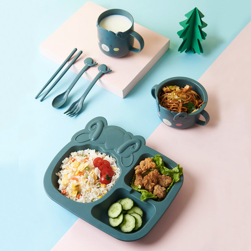 Children's lunch set with divided plate, cups, and cutlery on a light blue background