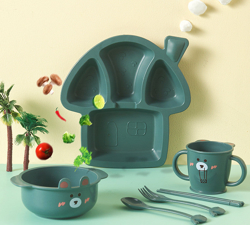 Children's tableware set with green bear-shaped plate, bowl, and mug on a light green background.