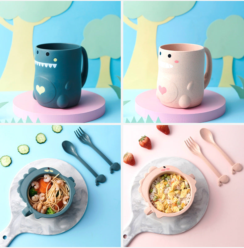 Set of children's tableware including mugs, bowls, and cutlery with cartoon designs on a colorful background.