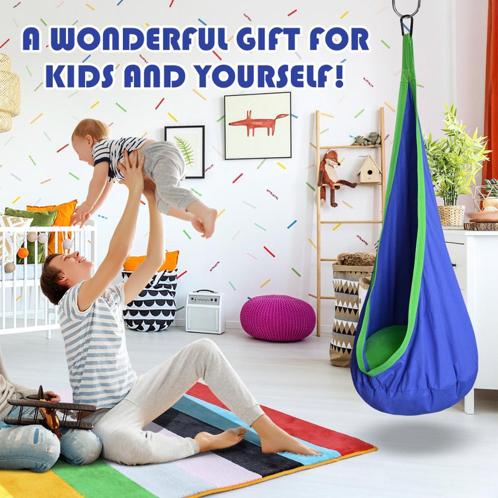 Child playing with a blue and green hanging chair in a colorful room.