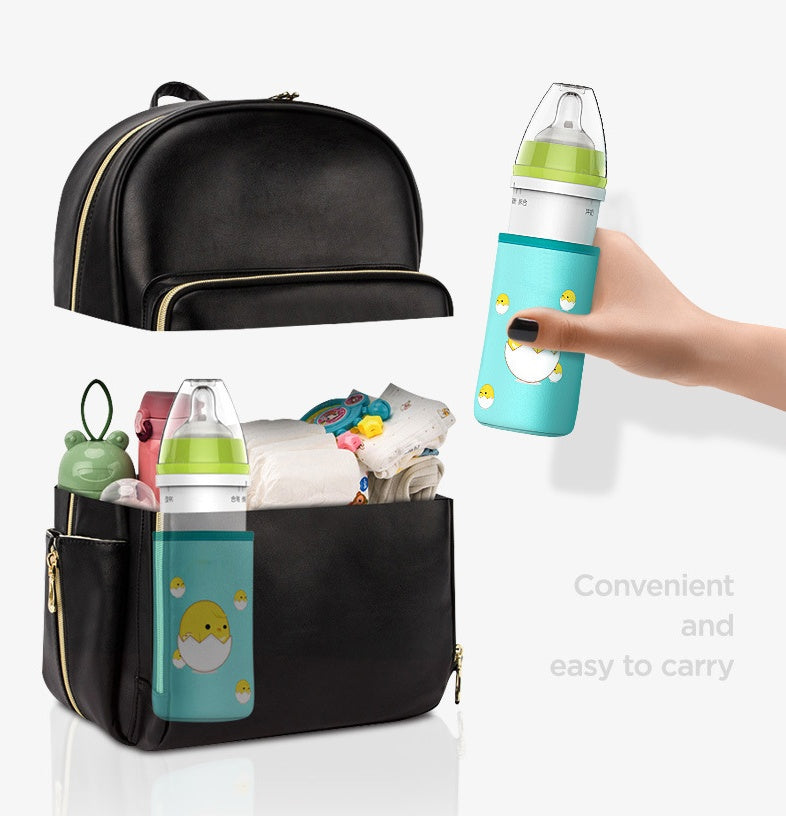 Black diaper bag with baby bottles and items, hand holding a blue bottle with cartoon design.