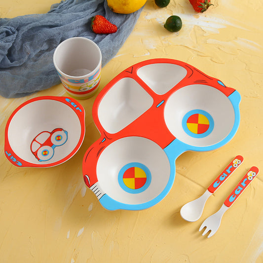 Colorful children's plate set with bowls, cup, and cutlery on a yellow surface.