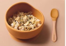 Bowl of popcorn with a wooden spoon on a beige background