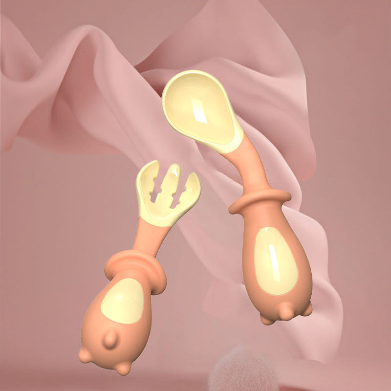 Pair of baby utensils with pink handles and yellow ends on a soft pink background