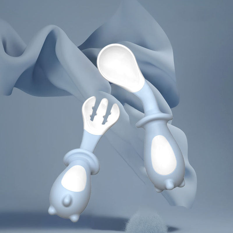 White baby utensils with a soft, blurred background