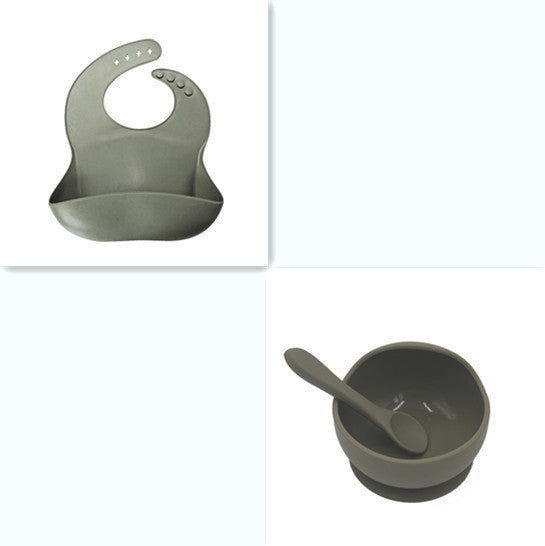 Set of green silicone bib, bowl, and spoon on a white background