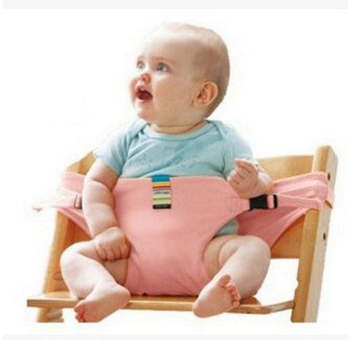 Baby sitting in a pink baby seat with a white background