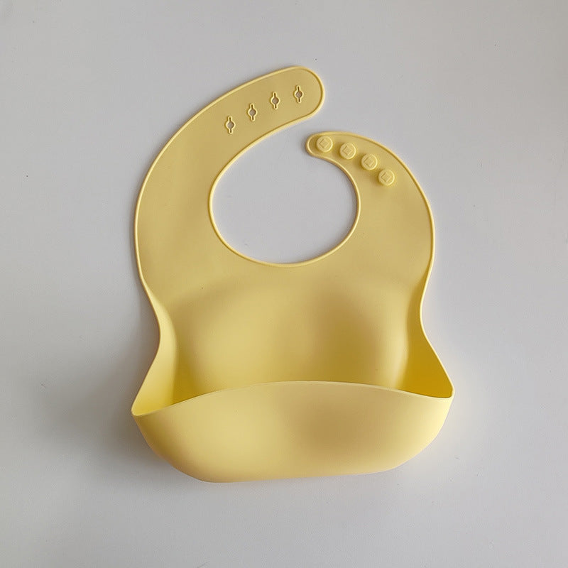 Yellow silicone bib on a light gray background