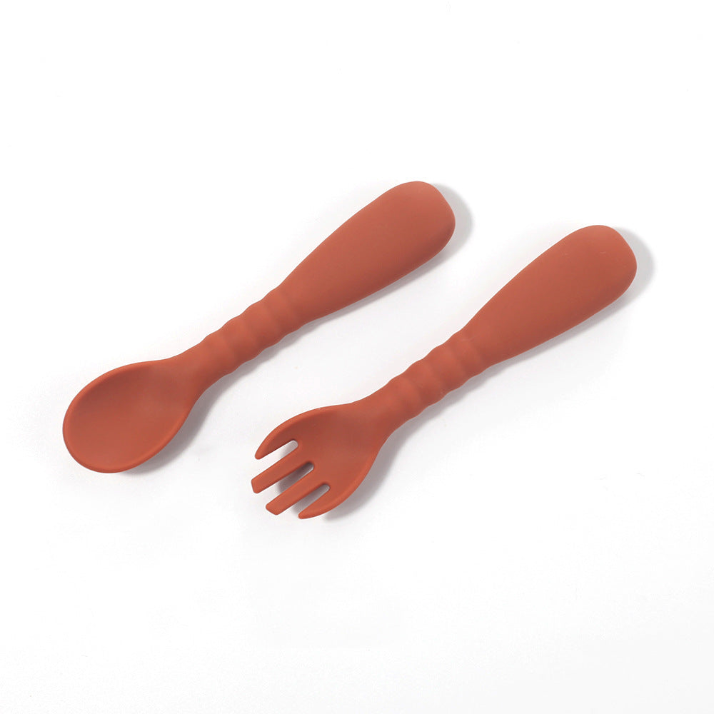 Set of red plastic spoon and fork on a white background